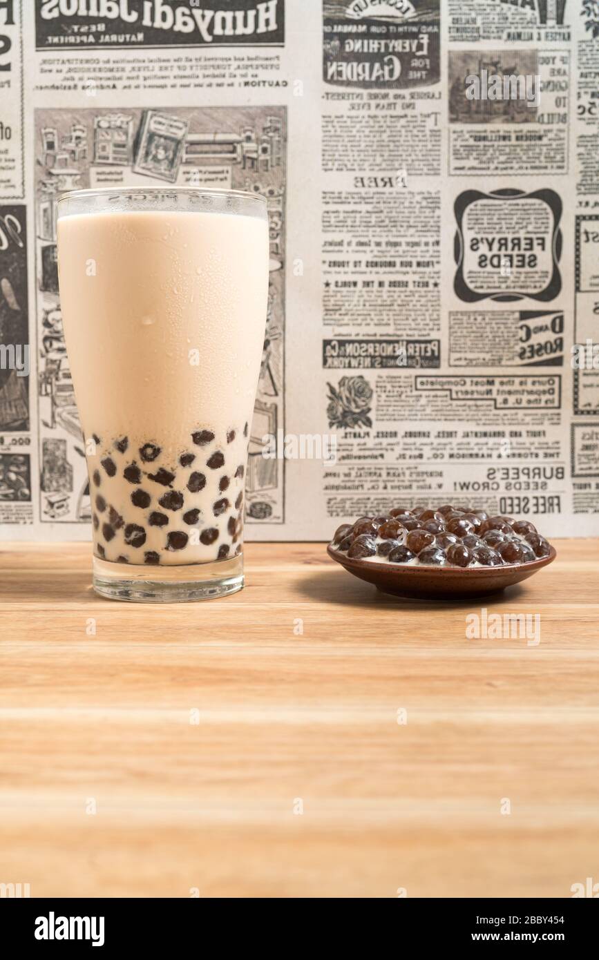 Ein Glas Tasse pearl Milch Tee (auch genannt Bubble Tea) und eine Platte von Tapioka Kugel auf Holz- Hintergrund. Pearl Milch Kaffee ist die repräsentativste dri Stockfoto