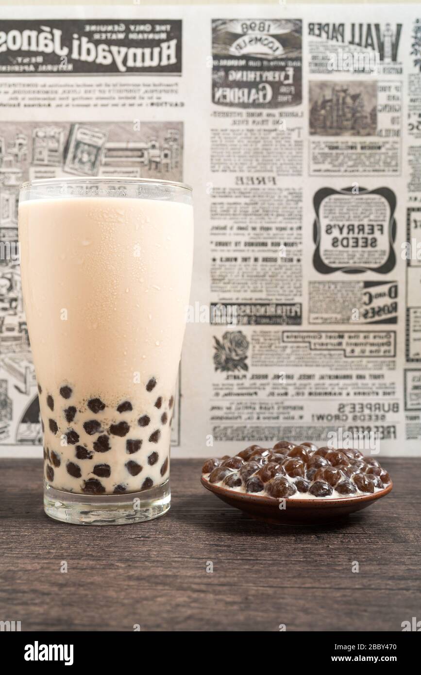 Ein Glas Tasse pearl Milch Tee (auch genannt Bubble Tea) und eine Platte von Tapioka Kugel auf Holz- Hintergrund. Pearl Milch Kaffee ist die repräsentativste dri Stockfoto