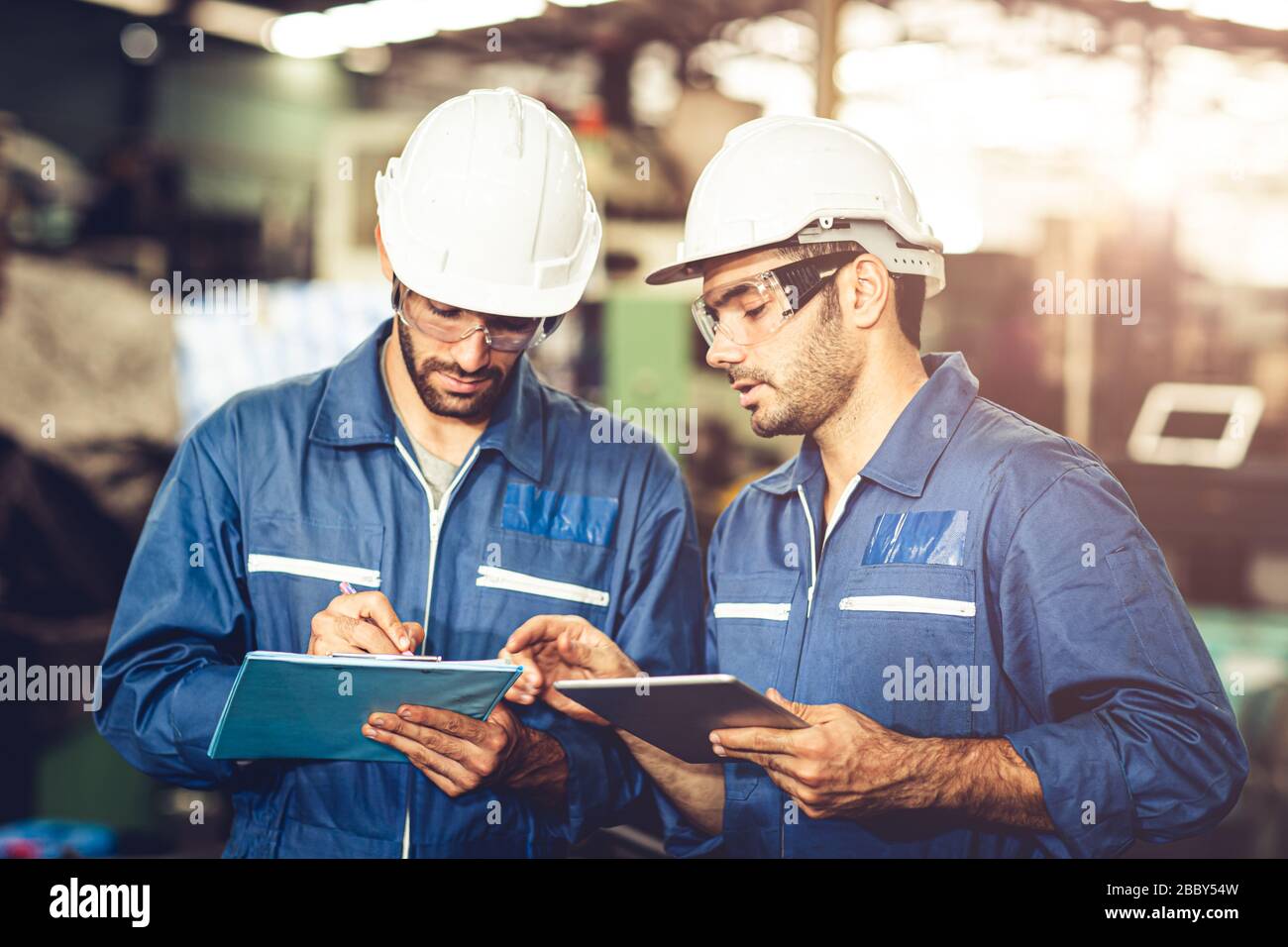 Engineer Audit Worker, das Team mit einem einheitlichen und weißen Helm für die Arbeit in der Industrie arbeitet, bearbeiten Tablette und Checkliste. Stockfoto