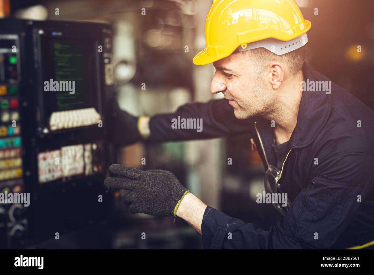 Professioneller Labor Worker Engineer Monitor am Maschinensteuertafel drücken Sie die Taste für die Programmierung der CNC-Bearbeitung. Stockfoto