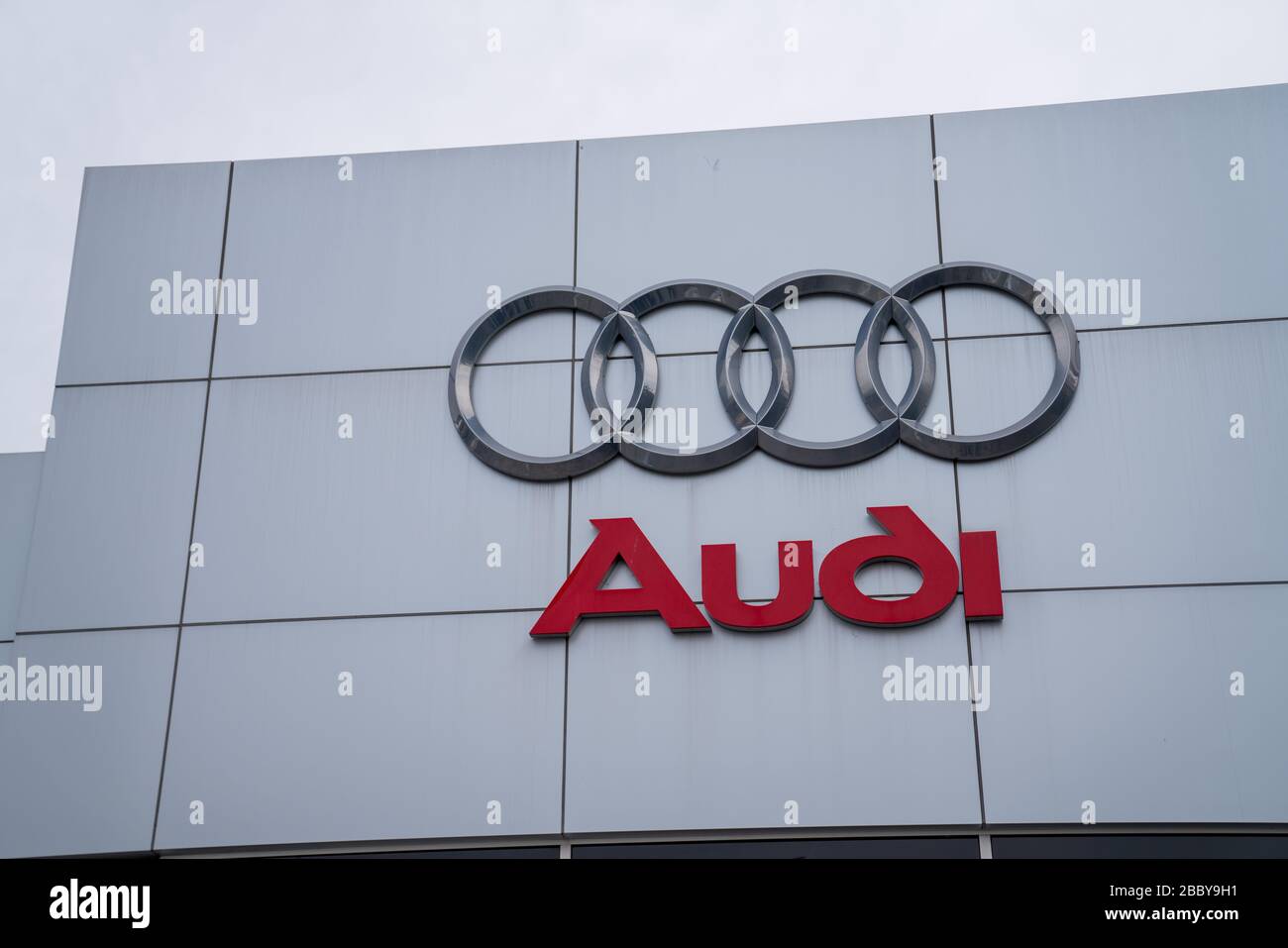 Audi Auto Logo und Schild vor dem Eingang des Autohauses Stockfoto