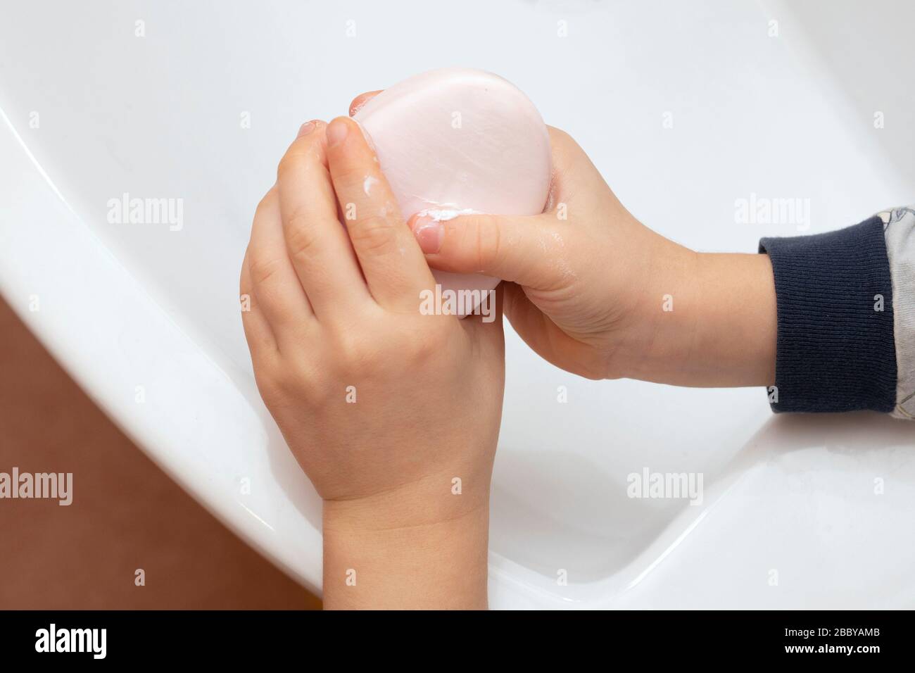 Das Kind wäscht, reinigt die Hände mit Seife. Hygienekonzept. Stockfoto
