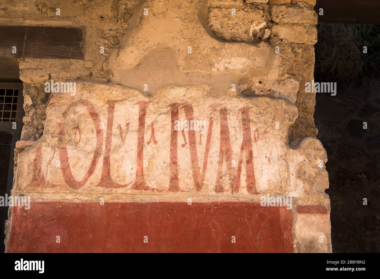 Ein Schild, das den Verkauf von Olivenöl an einer alten Mauer in Pompeji bei Neapel in Italien wirbt Stockfoto