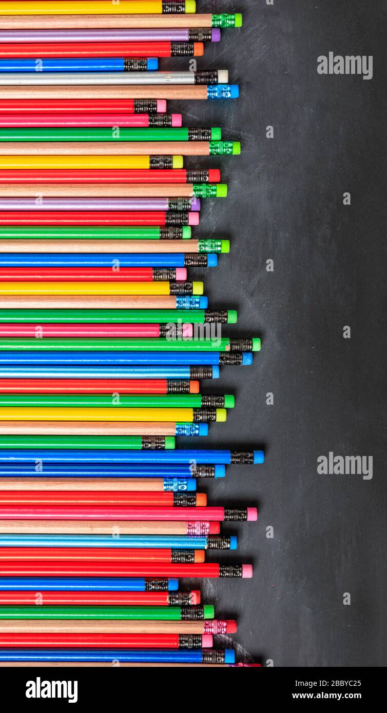 Schule, Bildungskonzept. Bunte Bleistifte mit Radierern auf Tafel, Kopierraum, vertikal Stockfoto