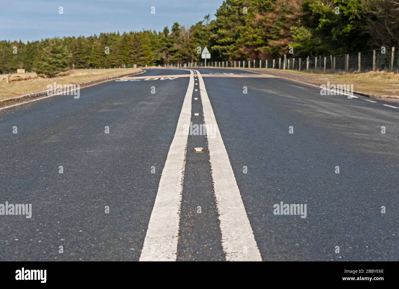 Straße in ländlicher Landschaft mit weißer Linie in Richtung Horizont Stockfoto