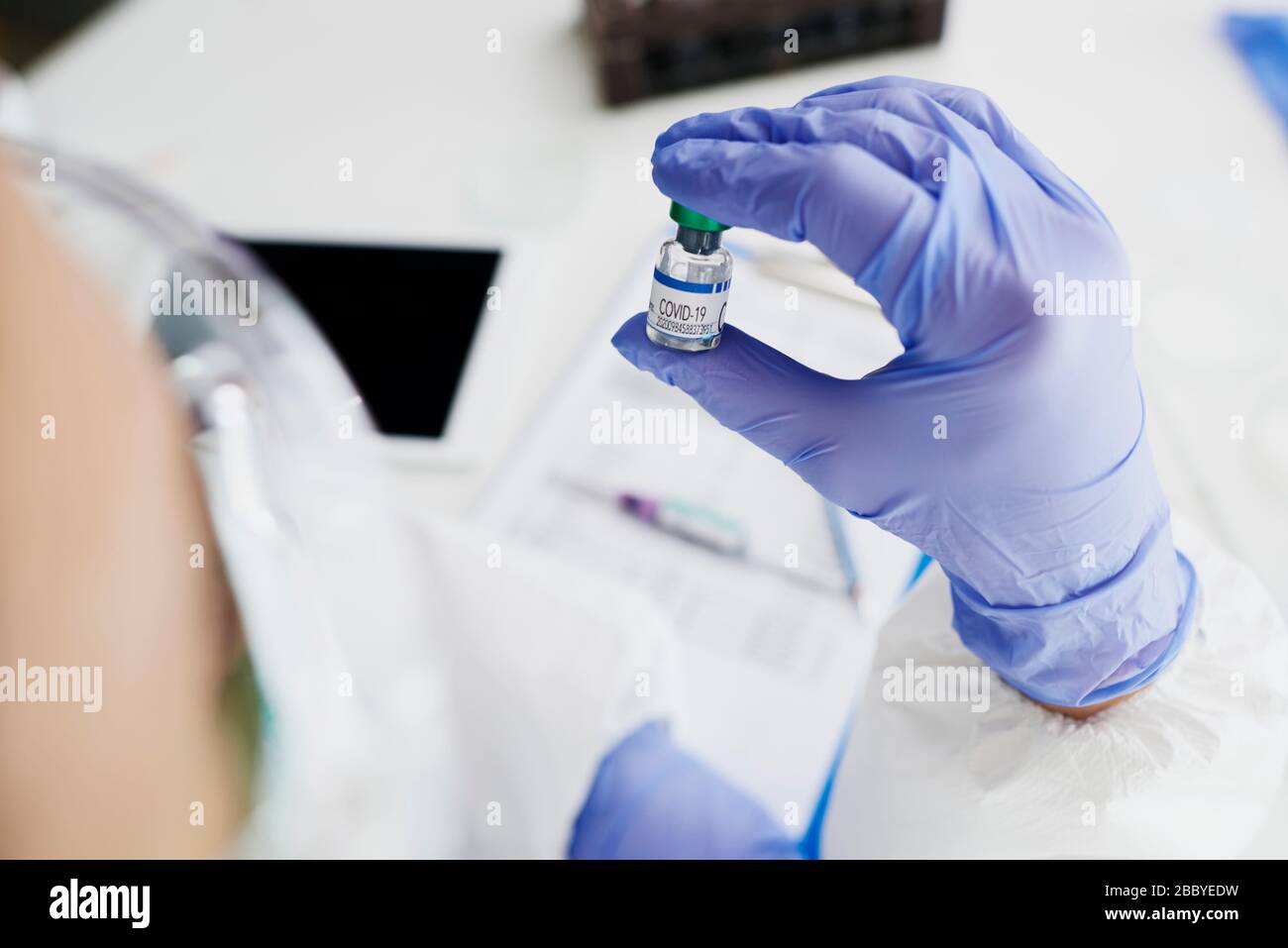 Techniker, der ein Ampulle mit Coronavirus Heilmittel hält Stockfoto