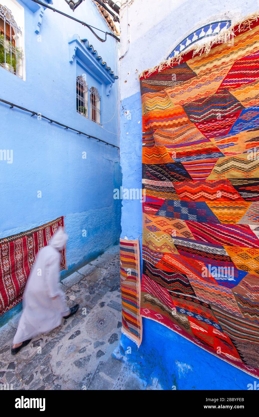 Chefchaouen, Marokko: Mann in einem weißen Djellaba, der in der Medina spazieren geht Stockfoto