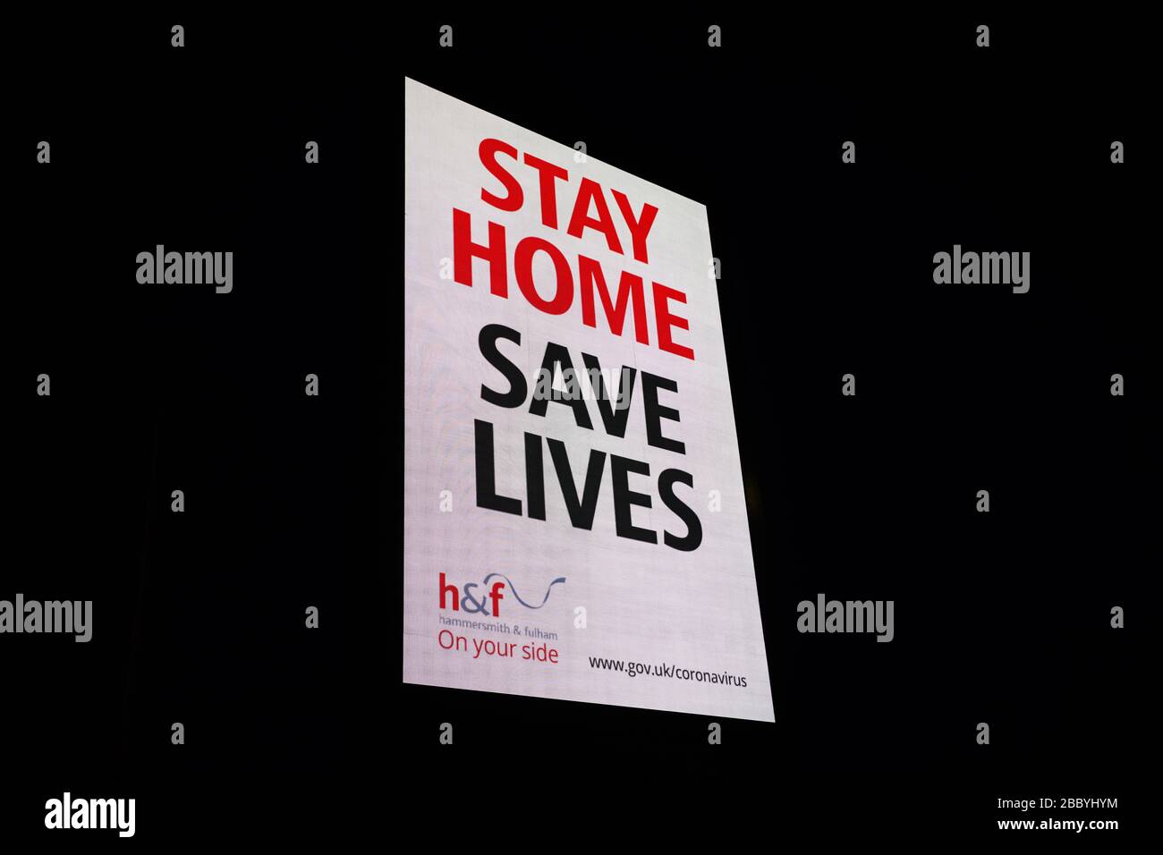 London, Großbritannien - 02. April 2020: Eine große elektronische Anzeigetafel von einem Londoner rat, die die Öffentlichkeit warnt, während der Coronavirus-Pandemie zu Hause zu bleiben, beleuchtet den Nachthimmel. Stockfoto