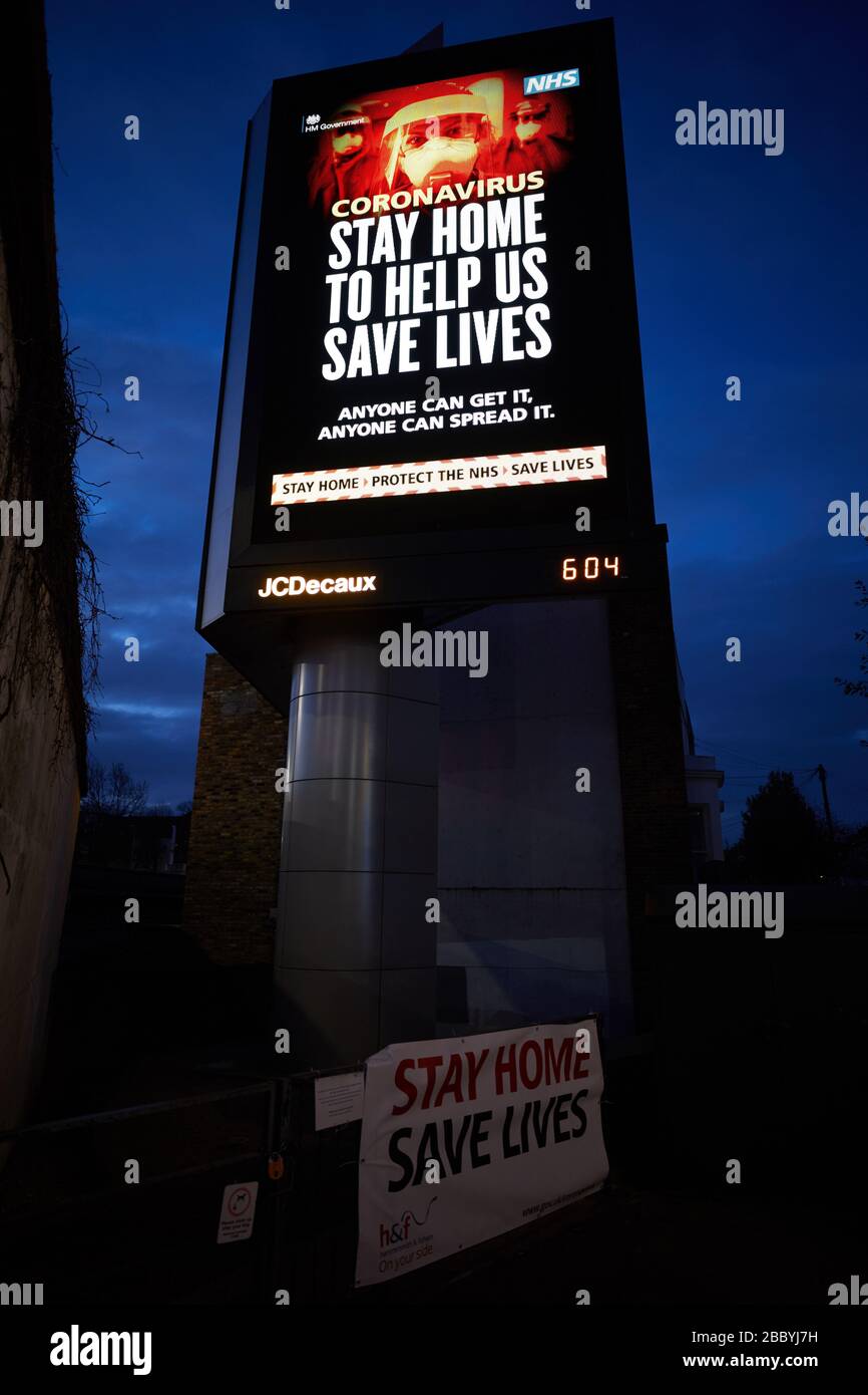 London, Großbritannien - 02. April 2020: Eine große elektronische Anzeigetafel der britischen Regierung, die die Öffentlichkeit warnt, während der Coronavirus-Pandemie zu Hause zu bleiben, beleuchtet den Nachthimmel. Stockfoto