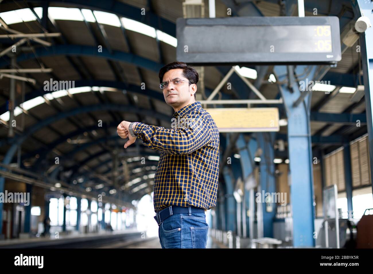Mann überprüft die Zeit, während er an der Metrostation wartet Stockfoto