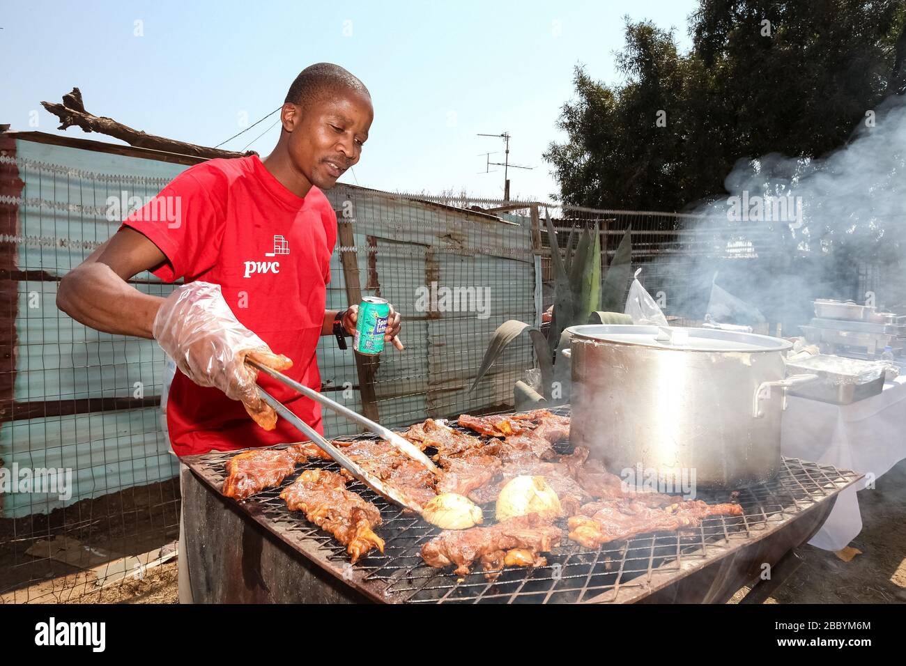 Soweto, Südafrika - 10. September 2011: Afrikanischer Mann, der einen Grill auf der Seitenstraße im städtischen Soweto arbeitet Stockfoto