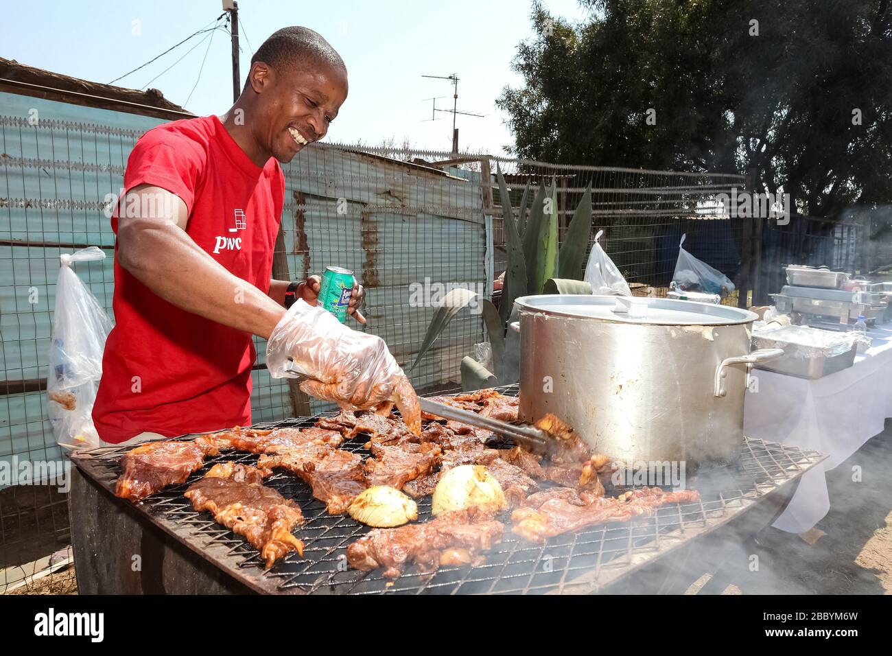 Soweto, Südafrika - 10. September 2011: Afrikanischer Mann, der einen Grill auf der Seitenstraße im städtischen Soweto arbeitet Stockfoto