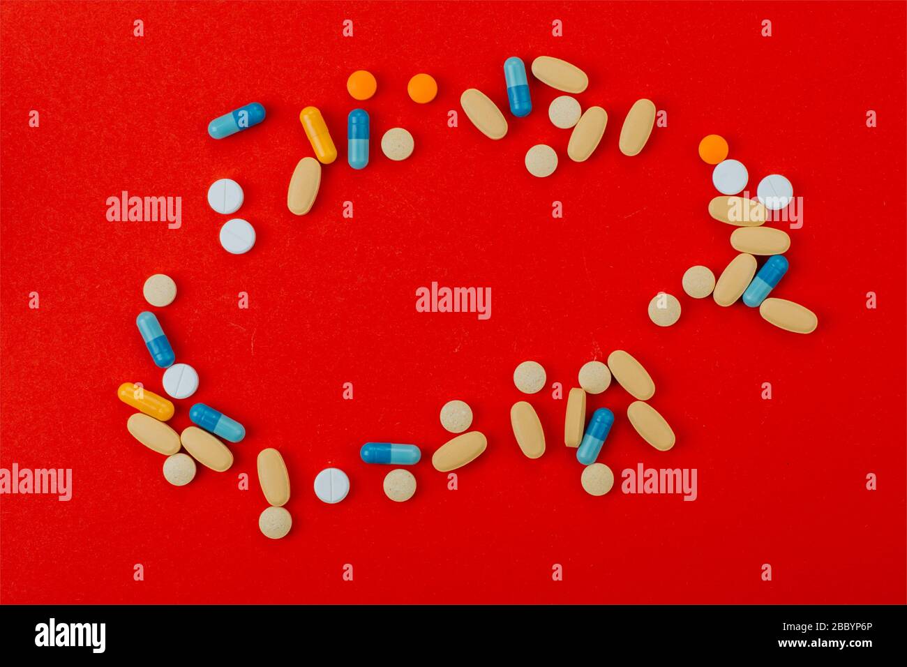 Verschiedene pharmazeutische Medikamente, Tabletten und Kapseln auf rotem Hintergrund. Stockfoto