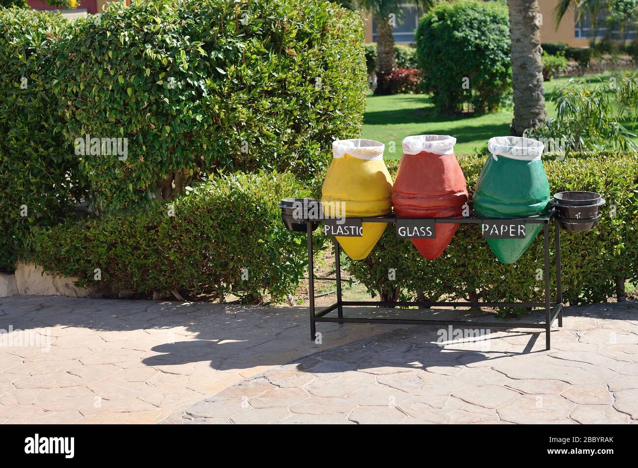 Drei Behälter für Abfallsortierung und Recycling. Gelbe, rote, grüne Markierungen an Abfallbehältern für Papier, Glas, Kunststoff am Strand im Hotel Stockfoto