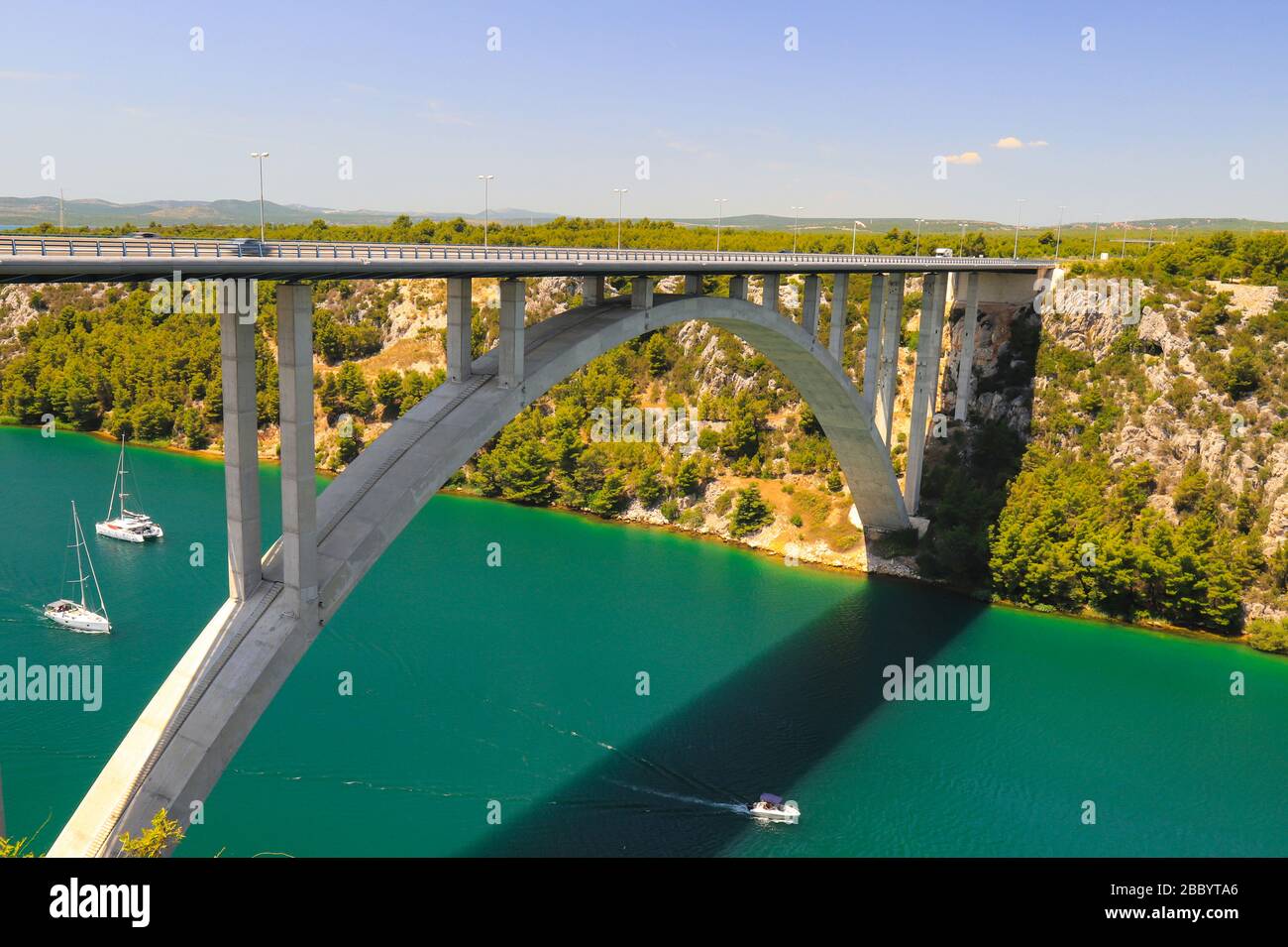Auto lange Hochbogenbrücke über den Fluss Krka in Kroatien bei Sibenik. Malerische kroatische Flusslandschaft im Frühling und Sommer, Europa Stockfoto