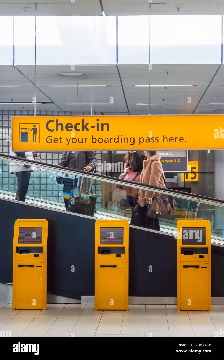 Schiphol, Niederlande - 16. Januar 2020: Holländisches gelbes Flughafencheck-in-Computer für den Erhalt einer automatisierten Bordkarte auf dem Flughafen Schiphol, TH Stockfoto