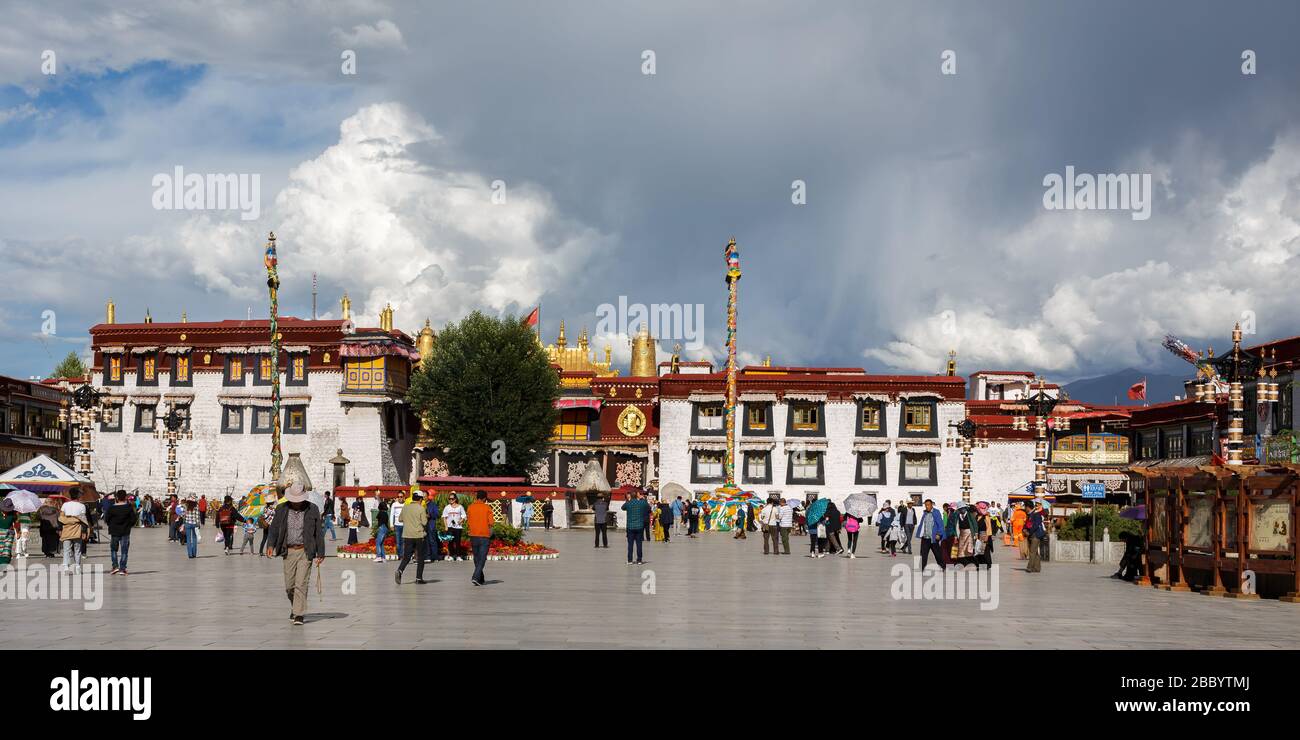 Panorama-Ansicht des Jokhang-Tempels mit bewölktem Himmel. Ein UNESCO-Welterbe und ein Zentrum des tibetischen buddhismus. Mit Pilgern und Besuchern. Stockfoto