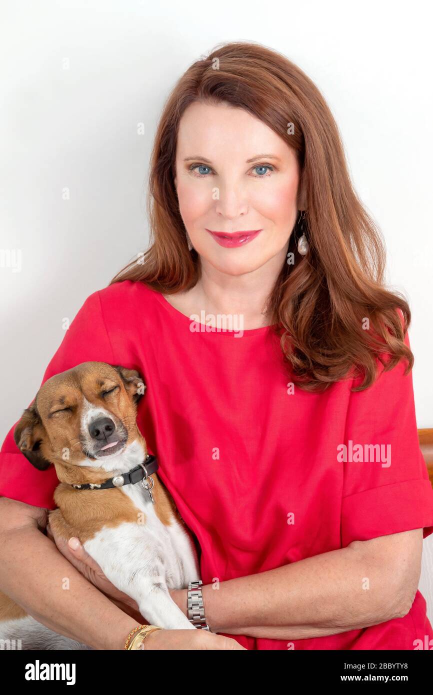 Sitzende Frau posiert mit ihrem süßen Hund Stockfoto