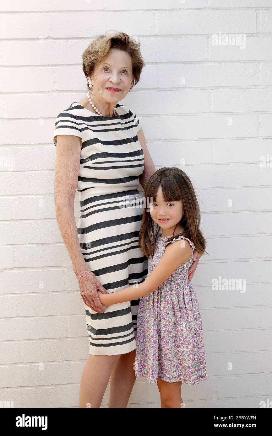 Fünf Jahre altes Mädchen vor, die neben ihrer Urgroßmutter Stockfoto