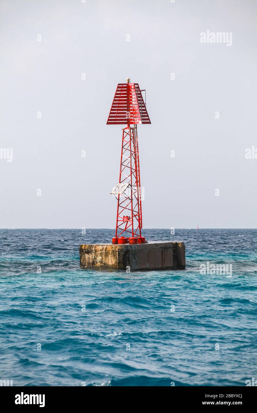 Rotes Leuchtfeuer mit Dreiecksmarkierung steht im Wasser des Persischen Golfes, Saudi-Arabien. Nahaufnahme des vertikalen Fotos Stockfoto