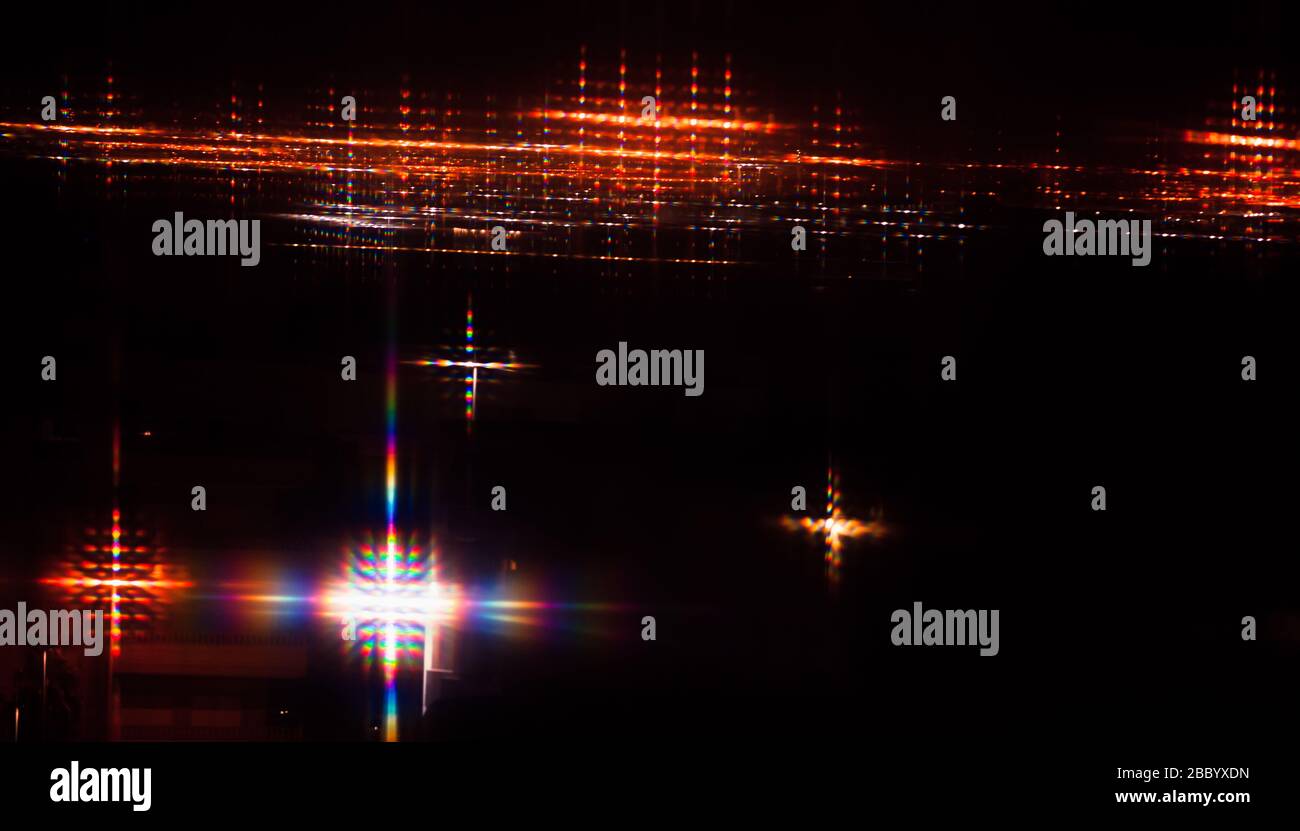 Abstraktes Hintergrundfoto mit farbenfrohem Streuungseffekt über Lichtflecken in der Nacht Stockfoto