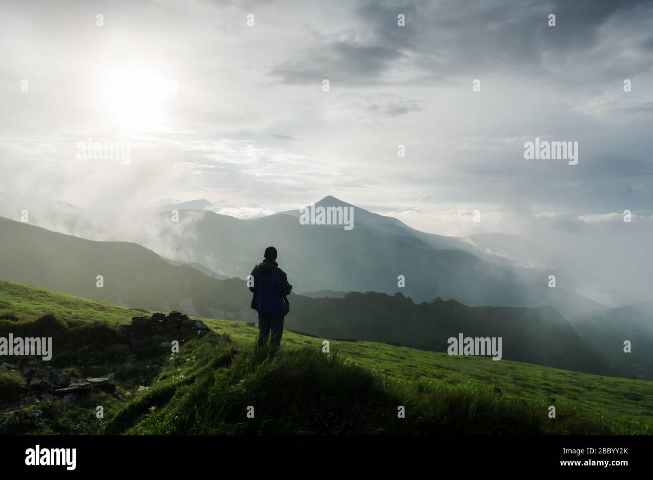 Mann Silhouette auf bewölkten Bergen. Reisekonzept. Landschaftsfotografie Stockfoto