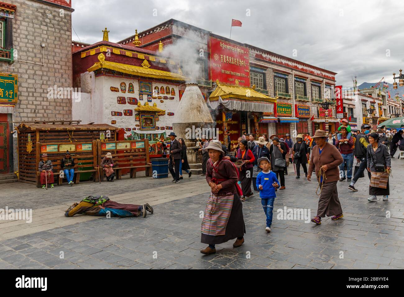 Pilger, die entlang der Barkhor Straße gehen. Die traditionelle Kora praktizieren - eine Art Pilgerfahrt und eine Art meditative Praxis im tibetischen Buddhismus. Stockfoto
