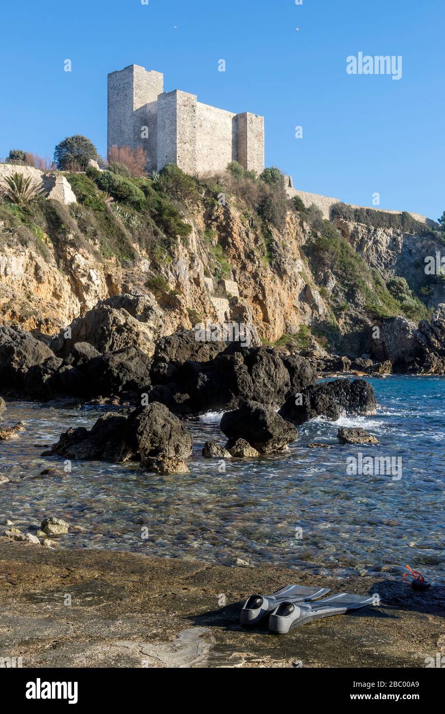 Die Flossen eines Tauchers mit der Rocca Aldobrandesca von Talamone im Hintergrund, Toskana, Italien Stockfoto