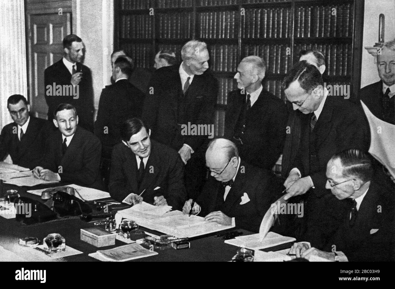 Churchill unterzeichnet eine Marinevertrag mit dem US-Botschafter, John Winant. Links: Vincent Massey, kanadischer Hochkommissar, 27. März 1941 Stockfoto