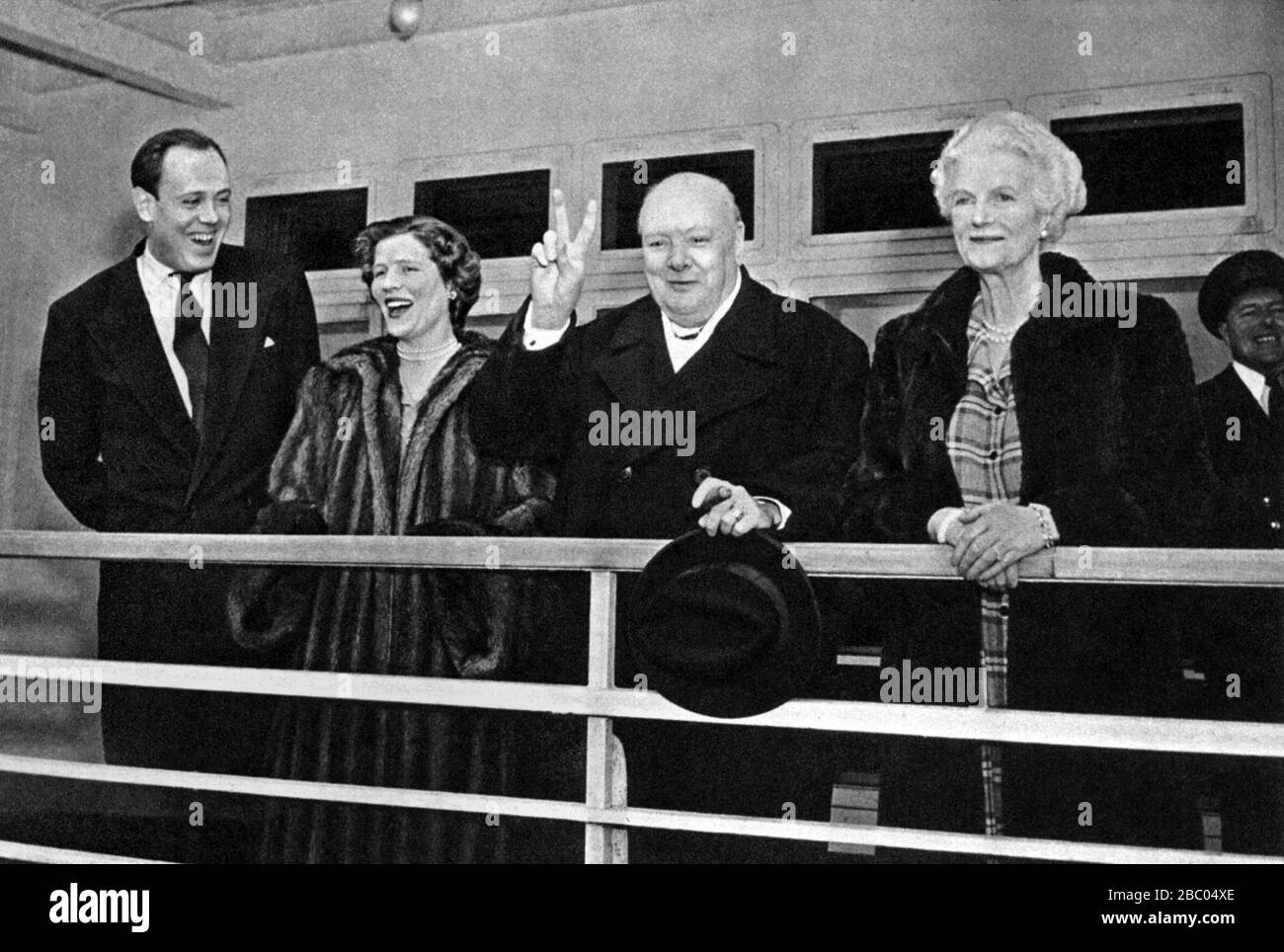 Churchill reagiert auf die Menge vom Deck des Liners Queen Elizabeth, der in New York ankommt. März 1949. Mit ihm: Seine Frau und Tochter. Stockfoto