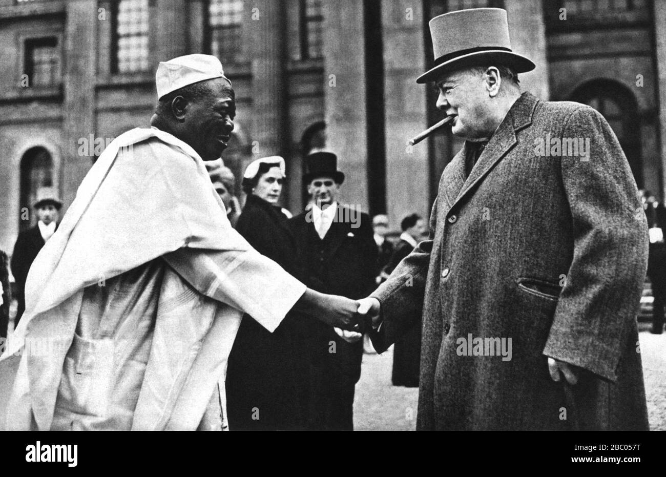 Winston Churchill schüttelt sich bei einer Gartenparty im Blenheim Palace mit dem nigerianischen Führer 'Oni of Ife' die Hände. Juni 1953 Stockfoto