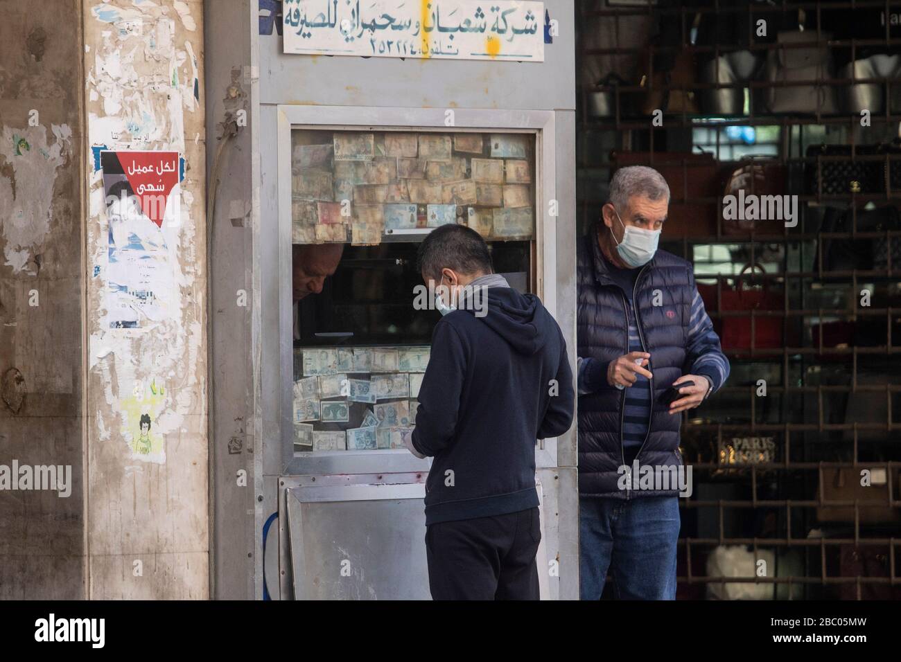 Beirut, Libanon. April 2020. Menschen, die auf das tragen von chirurgischen Masken warten, die vor einem Geldwechsler warten, während sich die Beiruter Bürger unter Sperrungen und wirtschaftlichen Schwierigkeiten an das Leben anpassen, nachdem die Regierung Quarantäne und nächtliche Sperrungen angeordnet hatte, die die Ausbreitung des neuen Coronavirus eindämmen sollten. Das neuartige Coronavirus verursacht für die meisten Menschen leichte oder mäßige Symptome, für ältere Erwachsene und Menschen mit bestehenden Gesundheitsproblemen kann es jedoch zu schwerer Krankheit oder Tod führen. Credit: amer ghazzal/Alamy Live News Stockfoto