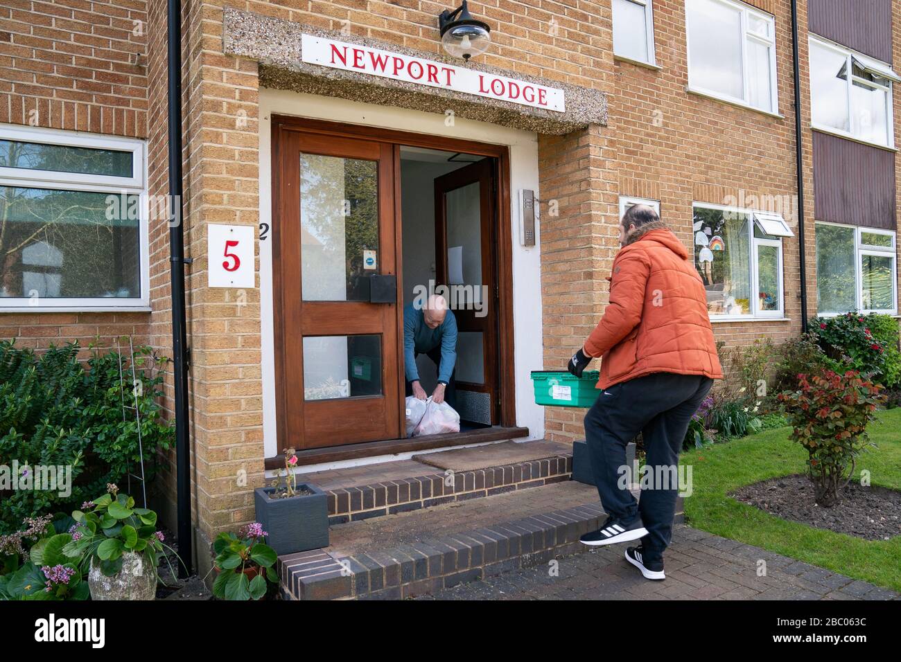 Tony Rosa liefert Lebensmittelpakete vom Enfield Council an Peter Hetherington in Enfield, North London. Stockfoto