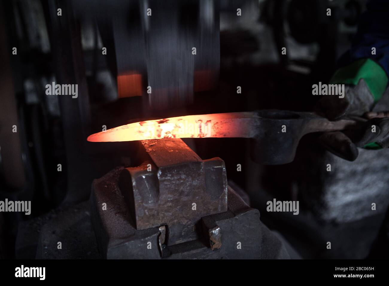 Am Amboss wird in der Schmiede der Hachlschmiede in der Josefinsthal am Schliersee eine Pickaxe mit einem Hammer geschlagen. Die Hammerschmiede existiert seit über 300 Jahren und beliefert nicht nur regionale Holzarbeiter und Waldbauer, sondern auch ein großes Bauunternehmen mit Werkzeugen. [Automatisierte Übersetzung] Stockfoto