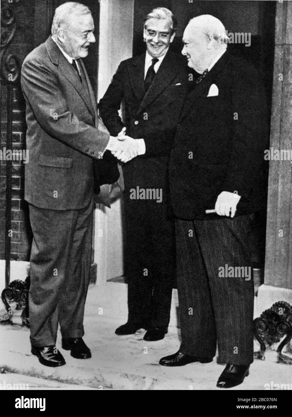 Winston Churchill schüttelt sich die Hände mit John Foster Dulles vor 10 Downing Street. Anthony Eden schaut zu. September 1954 Stockfoto