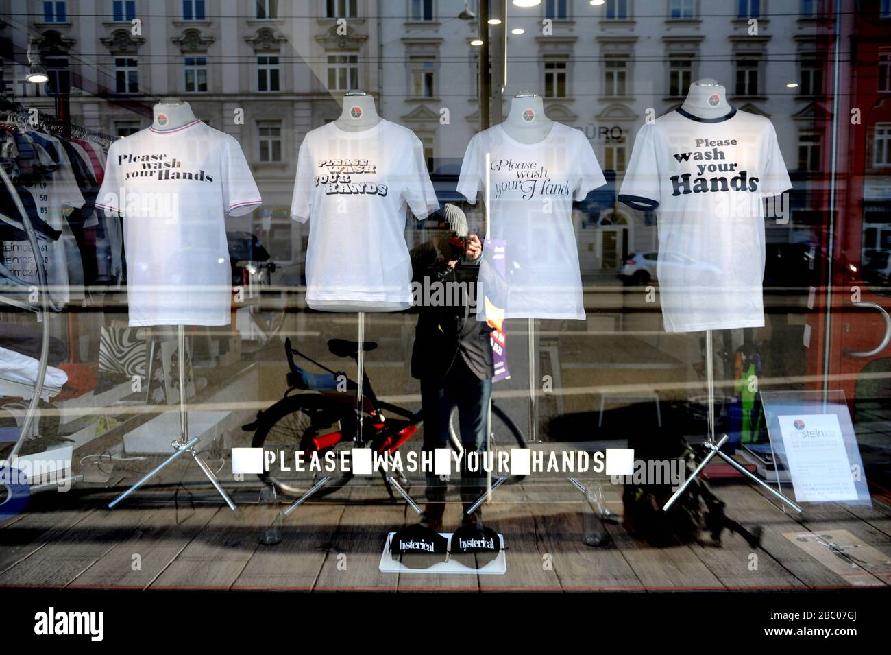 Das T-Shirt Shop- und Designbüro bei Einstein 102 hat T-Shirts mit dem Slogan "Corona Bitte waschen Sie sich Ihre Hände" im Schaufenster. [Automatisierte Übersetzung] Stockfoto