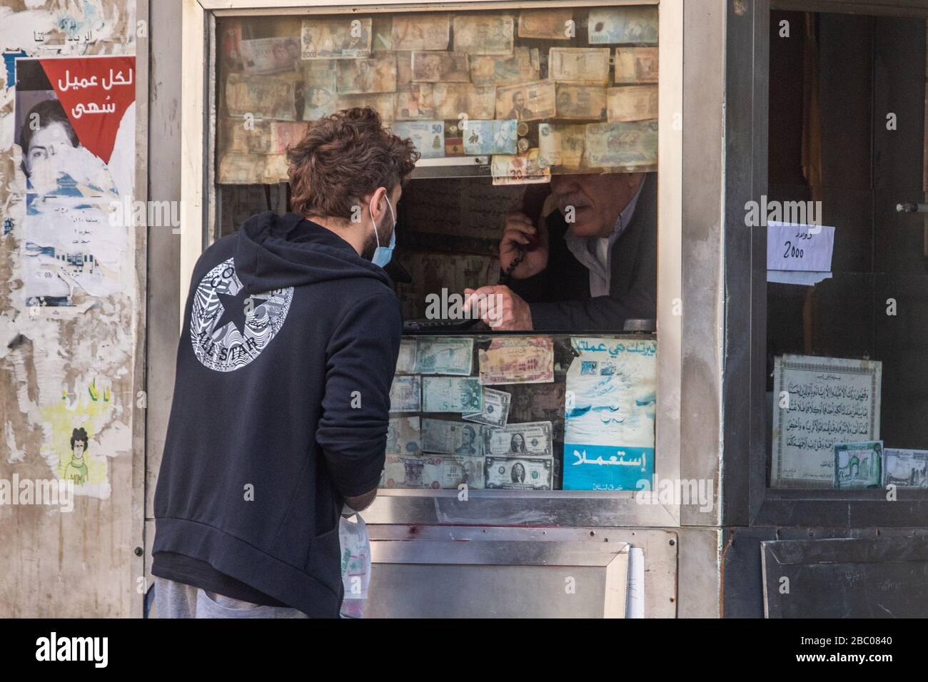 Beirut, Libanon. April 2020. Menschen, die auf das tragen von chirurgischen Masken warten, die vor einem Geldwechsler warten, während sich die Beiruter Bürger unter Sperrungen und wirtschaftlichen Schwierigkeiten an das Leben anpassen, nachdem die Regierung Quarantäne und nächtliche Sperrungen angeordnet hatte, die die Ausbreitung des neuen Coronavirus eindämmen sollten. Das neuartige Coronavirus verursacht für die meisten Menschen leichte oder mäßige Symptome, für ältere Erwachsene und Menschen mit bestehenden Gesundheitsproblemen kann es jedoch zu schwerer Krankheit oder Tod führen. Credit: amer ghazzal/Alamy Live News Stockfoto