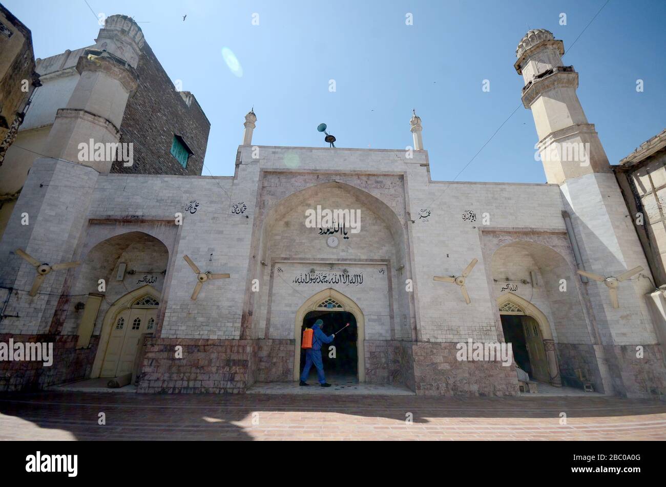 Peschawar, Pakistan. April 2020. Die Mitglieder des Teams der städtischen Körperschaft sprühen Desinfektionsmittel, um die Umgebung der Dilawar Khan Moschee und Straße nach einem Ausbruch des Corona-Virus in der Stadt Peschawar, Pakistan, zu sanieren. (Foto von Hussain Ali/Pacific Press) Credit: Pacific Press Agency/Alamy Live News Stockfoto