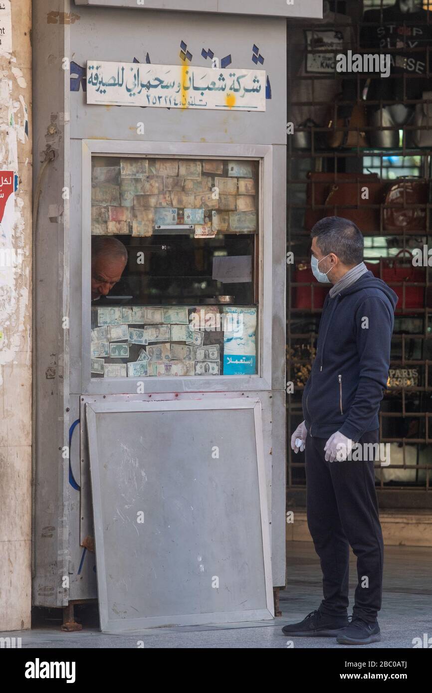 Beirut, Libanon. April 2020. Menschen, die auf das tragen von chirurgischen Masken warten, die vor einem Geldwechsler warten, während sich die Beiruter Bürger dem Leben unter Lockerung und wirtschaftlicher Not anpassen, nachdem die Regierung Quarantäne und nächtliche Sperrungen angeordnet hatte, die die Ausbreitung des neuen Coronaviru eindämmen sollten. Das neuartige Coronavirus verursacht für die meisten Menschen leichte oder mäßige Symptome, für ältere Erwachsene und Menschen mit bestehenden Gesundheitsproblemen kann es jedoch zu schwerer Krankheit oder Tod führen. Credit: amer ghazzal/Alamy Live News Stockfoto