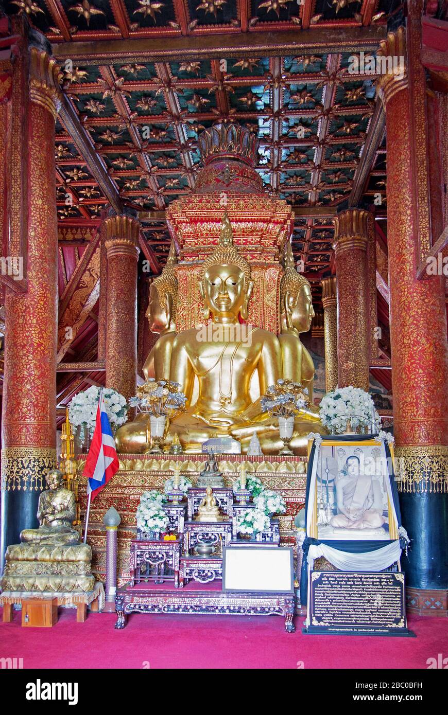Sitzender Buddha dominiert den zentralen Raum des Tempels in erdberührender Position, umgeben von vier riesigen Teakholz-Säulen. Stockfoto