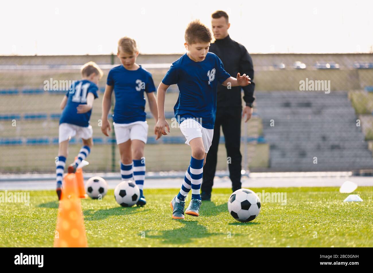 Young Boys in Sports Soccer Club on Training Unit. Kinder verbessern die Fußballfähigkeiten auf dem natürlichen Rasengras-Pitch. Fußball-Übungssitzung für Kinder Stockfoto