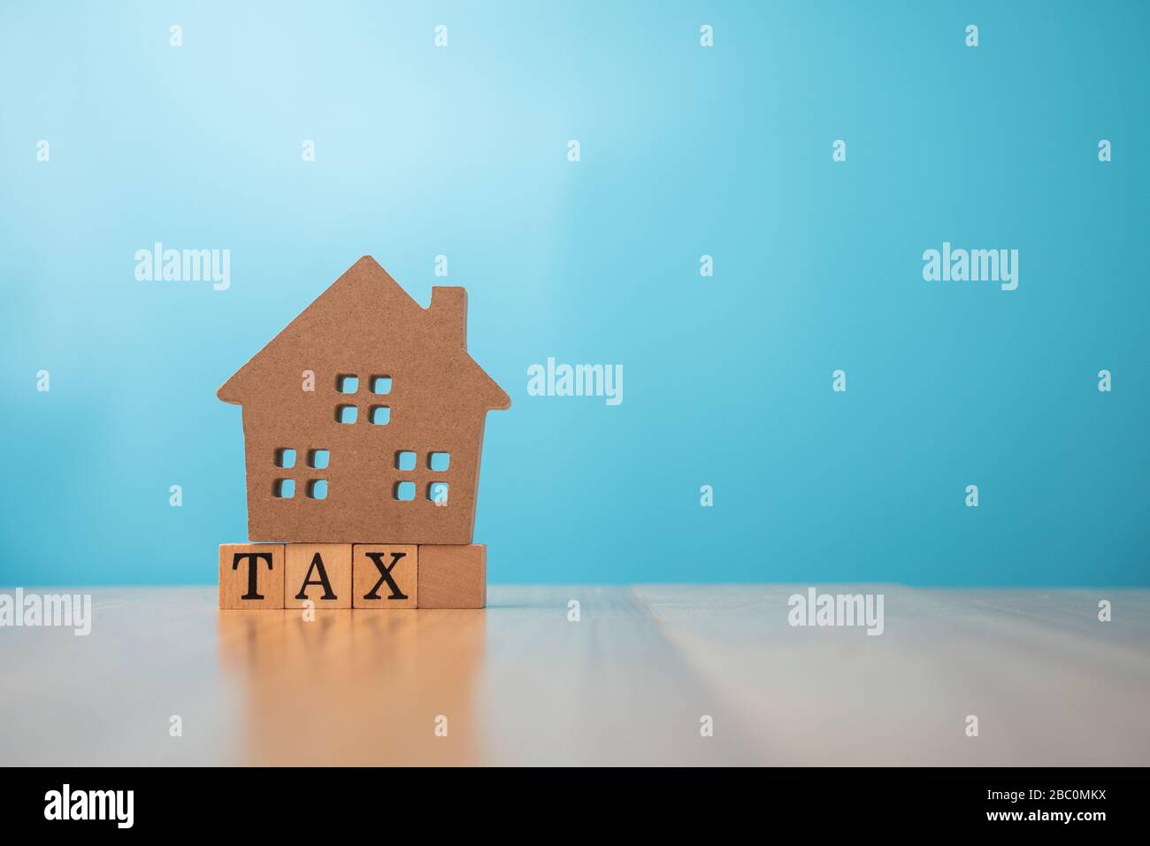 Holzhaus auf Steuern. Das Konzept der Finanzierung und Investition in Immobilien- und Steuerzahlungen. Stockfoto