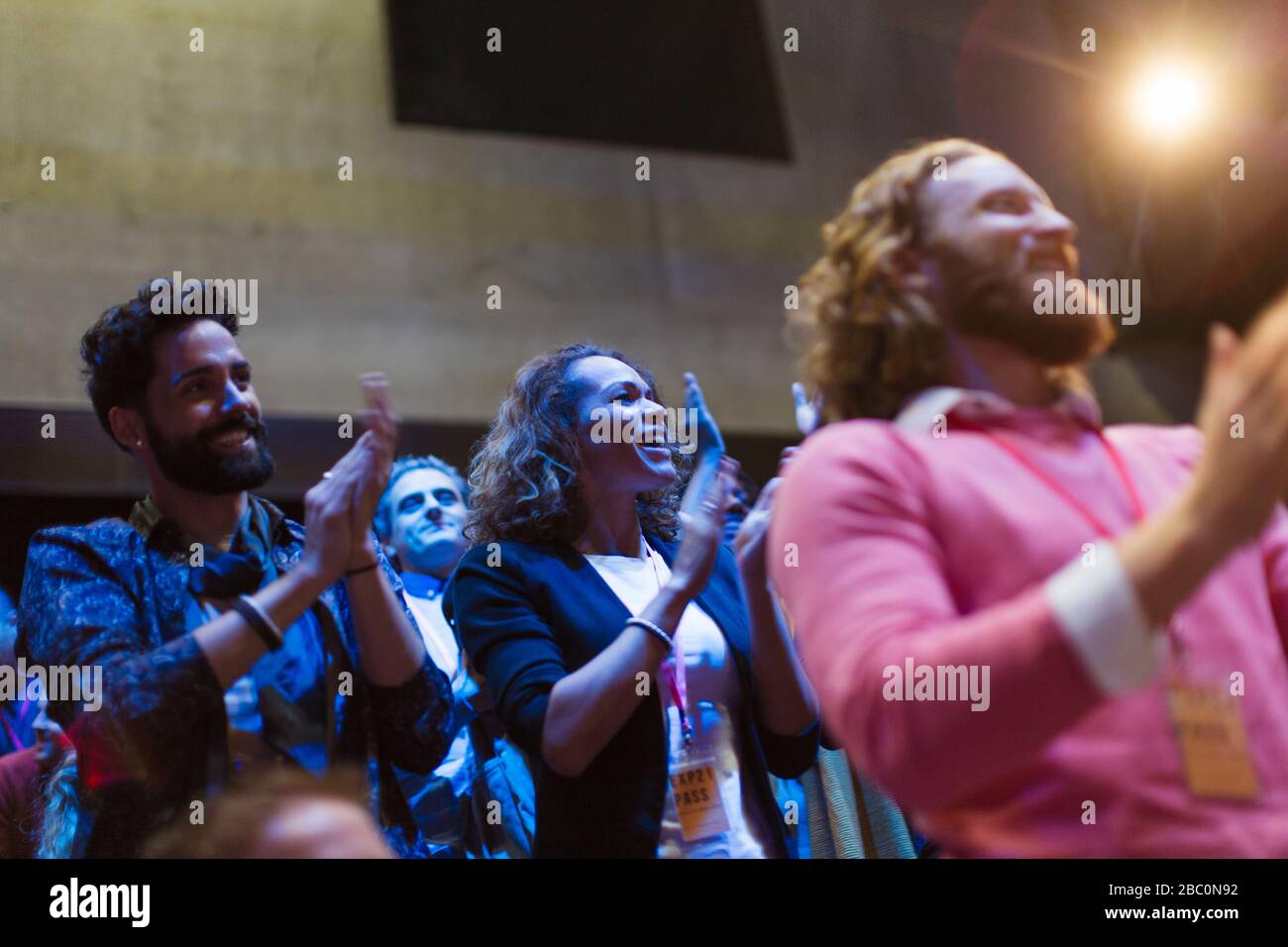 Aufgeregtes Publikum klatscht im dunklen Raum Stockfoto