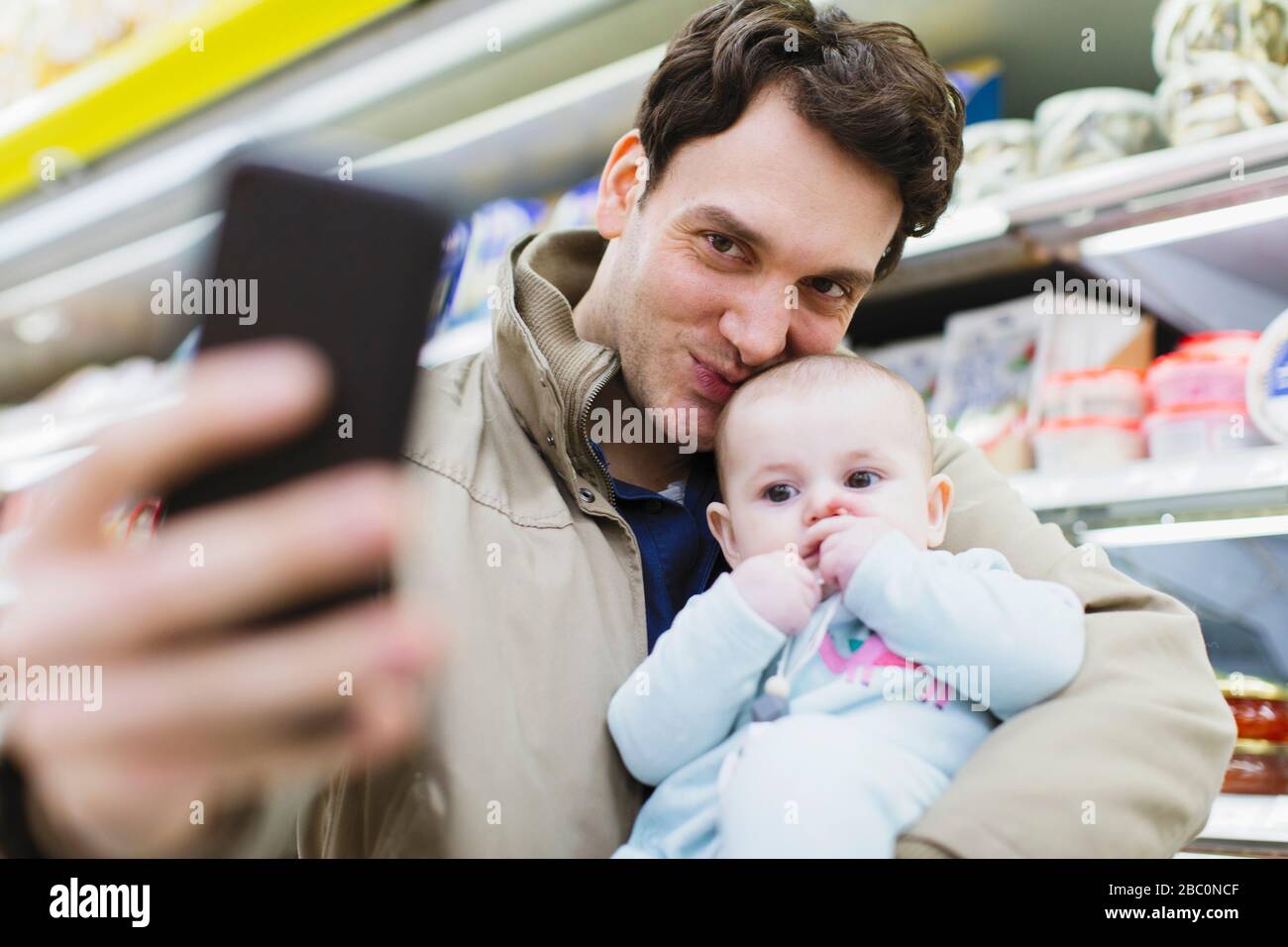 Liebevoller Vater und Tochter, die selfie im Supermarkt einnehmen Stockfoto