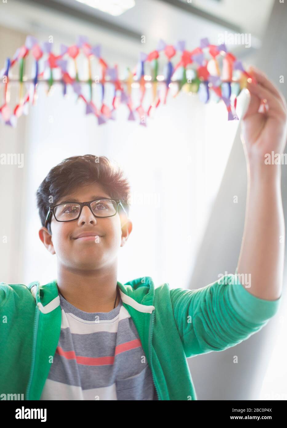 Junge Studentin untersucht DNA-Modell im Klassenzimmer Stockfoto