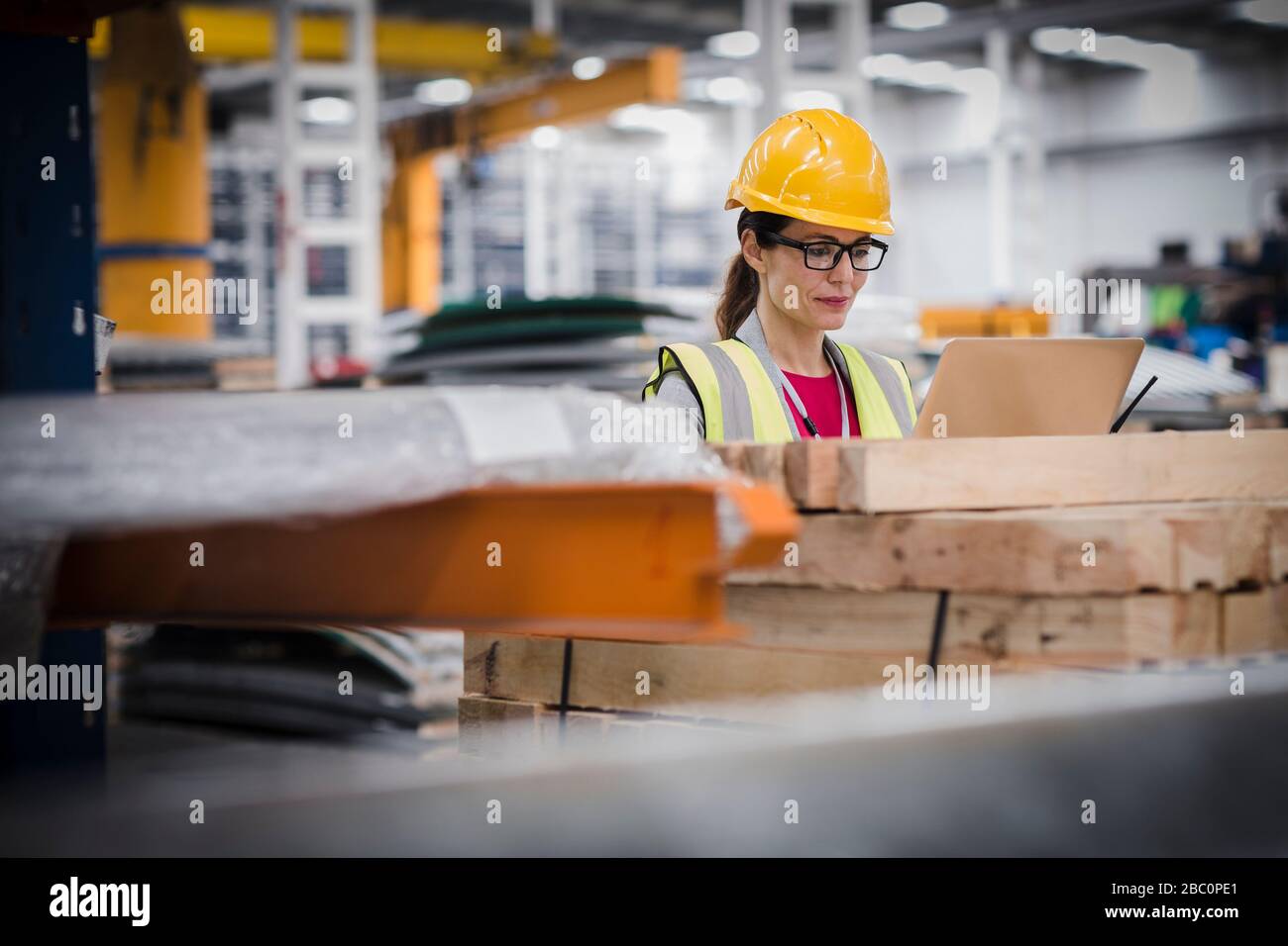 Arbeiterin mit Laptop in der Factory Stockfoto