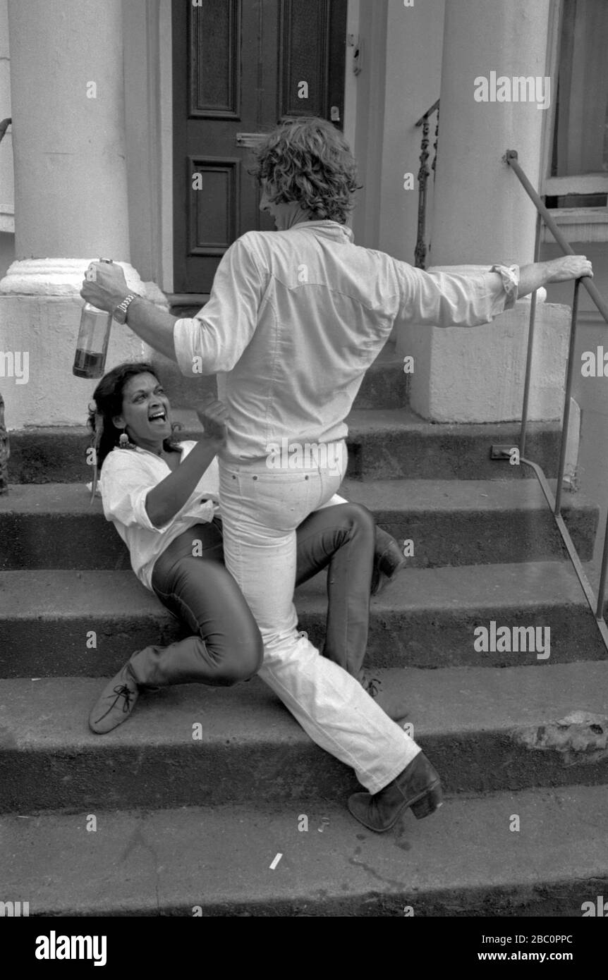 Paare tanzen, beide sind betrunken 1981 während der Notting Hill Karneval. 1980er Er hält eine Flasche Alkohol in der Hand. UK HOMER SYKES Stockfoto