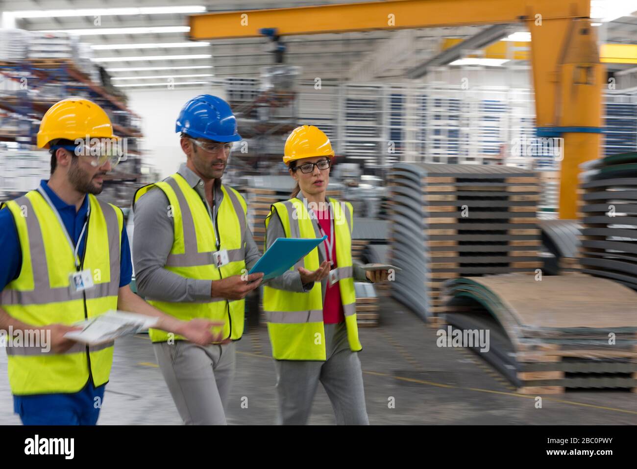 Vorgesetzter und Mitarbeiter mit Zwischenablage und digitalem Tablet-PC im Werk Stockfoto