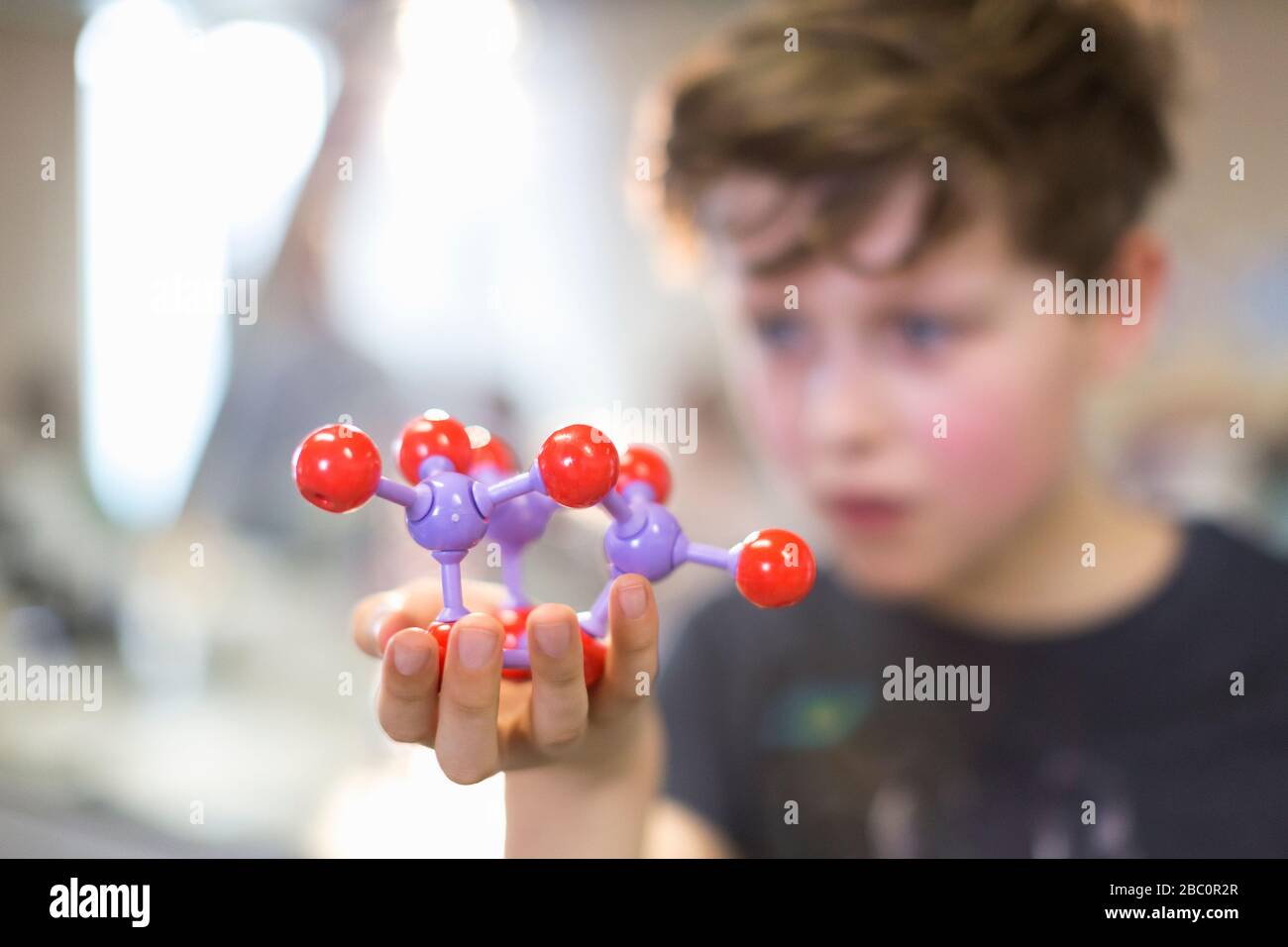 Junge Student hält und untersucht Molekularstruktur Stockfoto