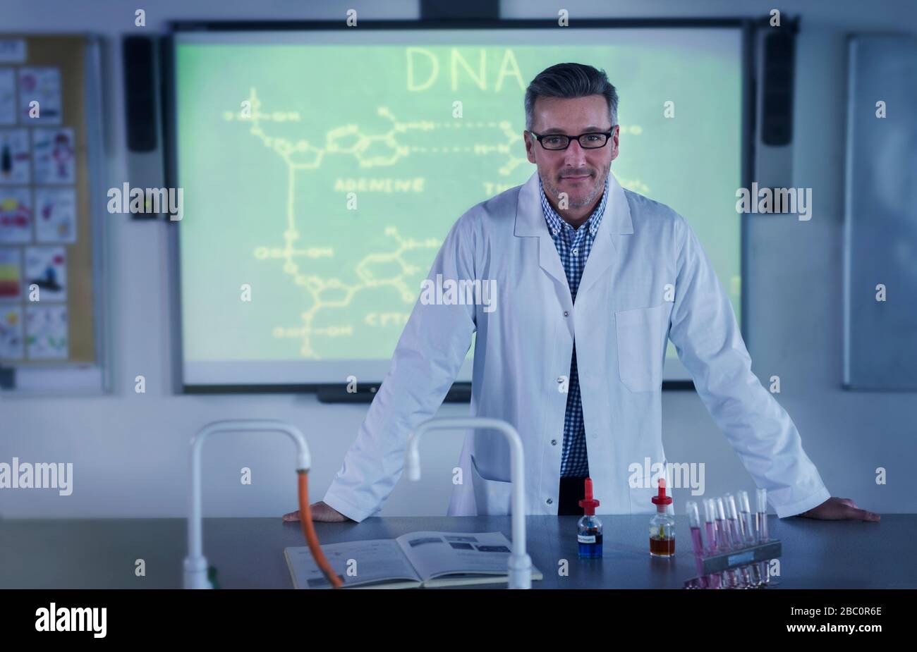 Portrait männlicher Lehrer für Naturwissenschaften, der DNA-Unterricht auf der Projektionsleinwand unterrichtet Stockfoto